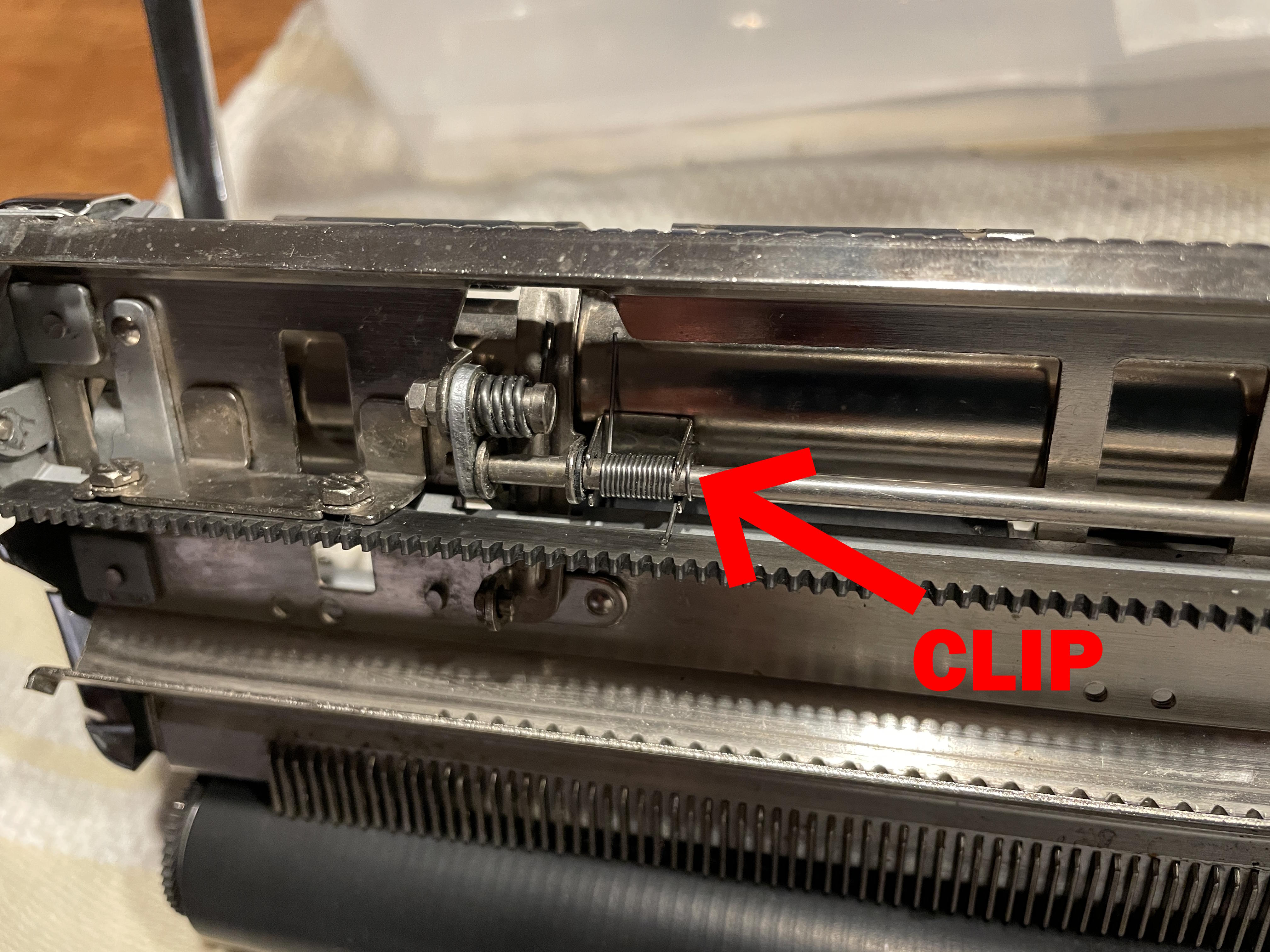 One of the springy clips holding paper tray in place