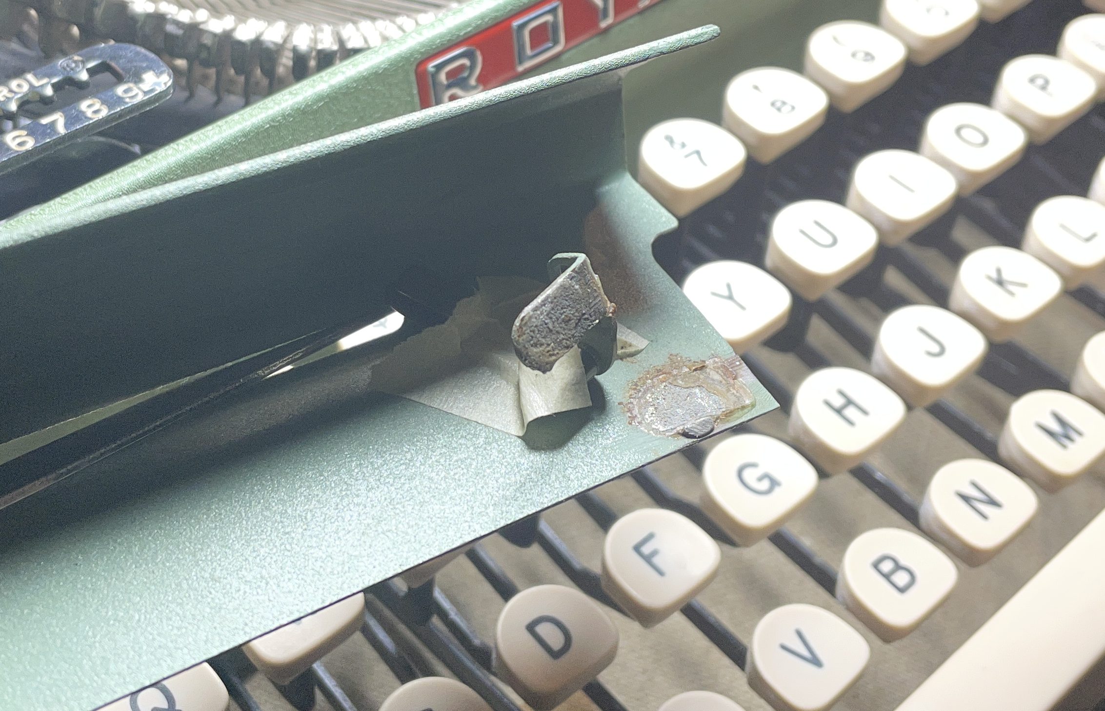 broken arm on back cover plate of 1957 Royal Quiet De Luxe with broken shift and shift lock keys on left
